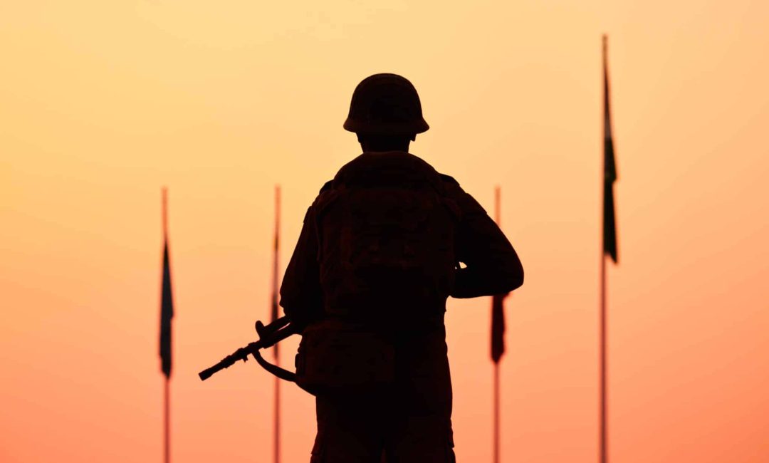 Rear,View,Of,Silhouette,Of,Soldier,In,Military,Gear,Holds